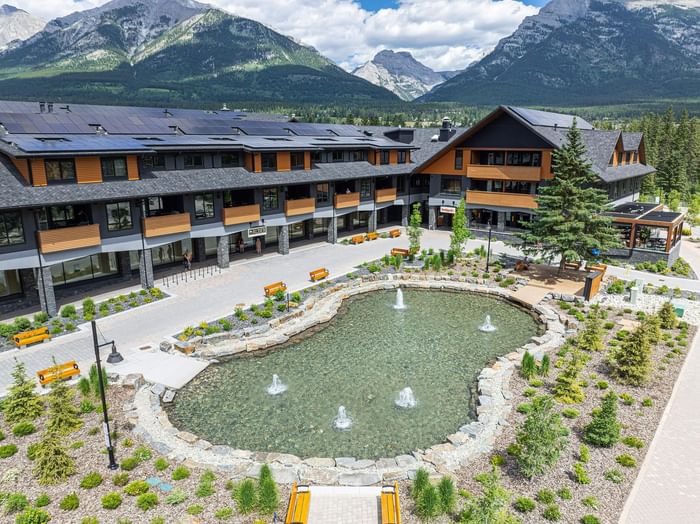 Aerial view of Timberstone Mountain Lodge with a fountain and mountain backdrop at Spring Creek Vacations