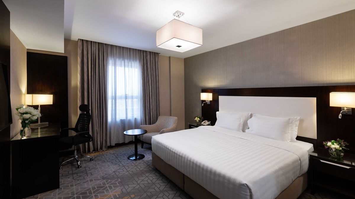 Work desk, nightstand, and cozy lounge chair by the bed in Executive Two-Bedroom Suite at Warwick Hotel Jeddah