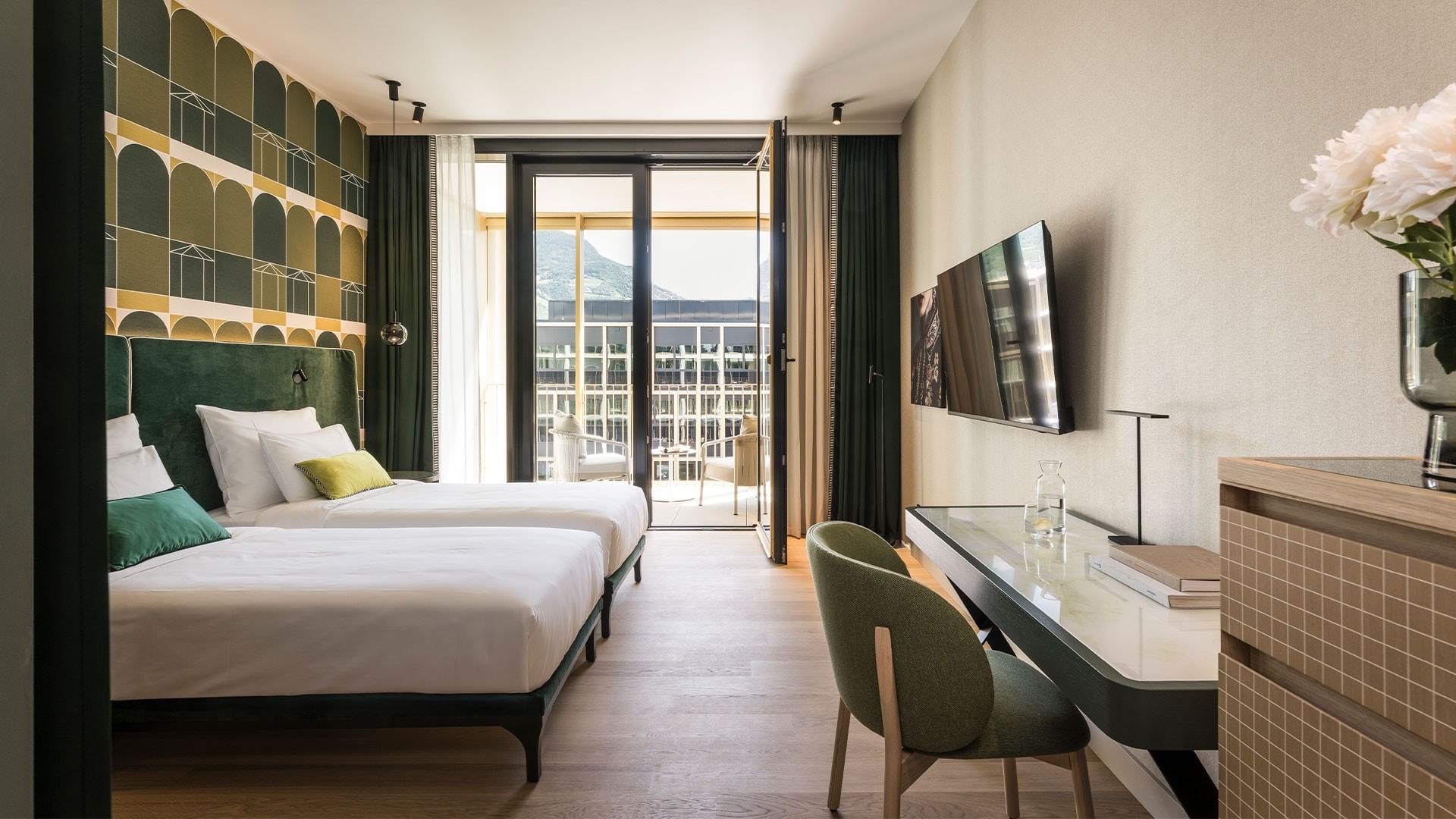 Elegantes Grand Deluxe Zimmer mit Balkon und Blick auf die Stadt beim Falkensteiner Hotel Bozen WaltherPark.