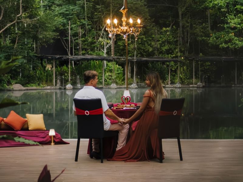 Couple holding hands at a table with a romantic Valentine's Day dinner promoting The Banjaran Hotsprings Valentine's Day promotion