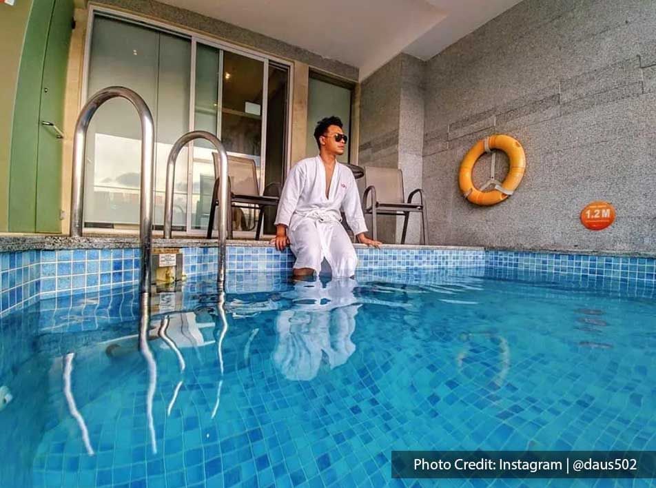 A guy in a bathrobe chilling in the private pool of Lexis Suites Penang.