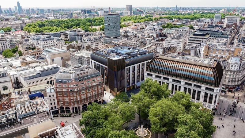 Stunning aerial view of London, showcasing the modern architecture of The Londoner Hotel amidst a bustling cityscape