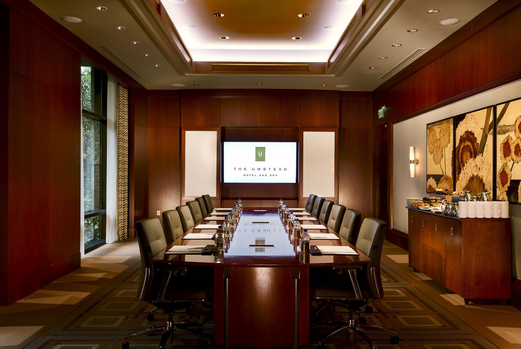 Boardroom-style table set up with a screen in the Ballroom at Umstead Hotel and Spa