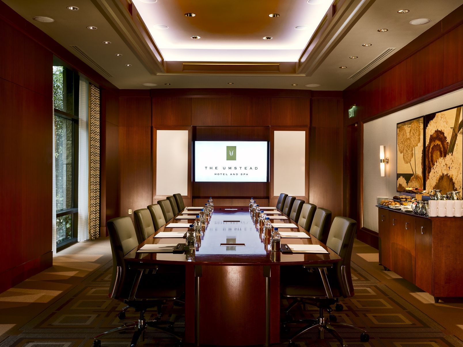 Boardroom-style table set up with a screen in the Ballroom at Umstead Hotel and Spa