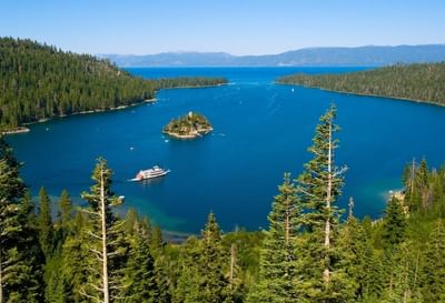 High-angle scenic view of Emerald Bay with a boat passing and Fannette Island in the center near Americana Village Suites