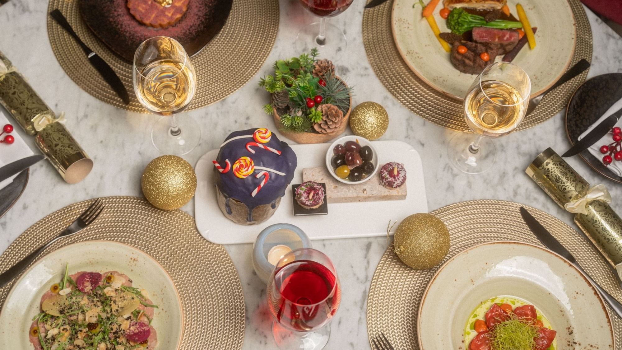 Elegantly set festive dinner table with gourmet dishes and wine glasses at Paramount Hotel Midtown