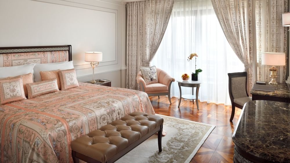 King bed, table lamp & chair in bedroom at Palazzo Versace