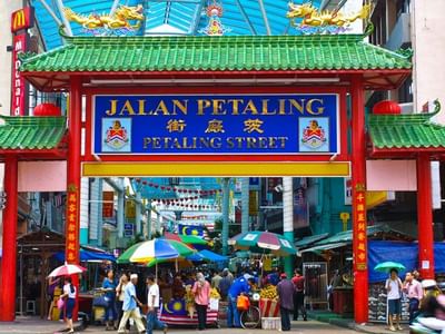 Iconic archway to Petaling Street Market with people and stalls near Sunway Velocity Hotel