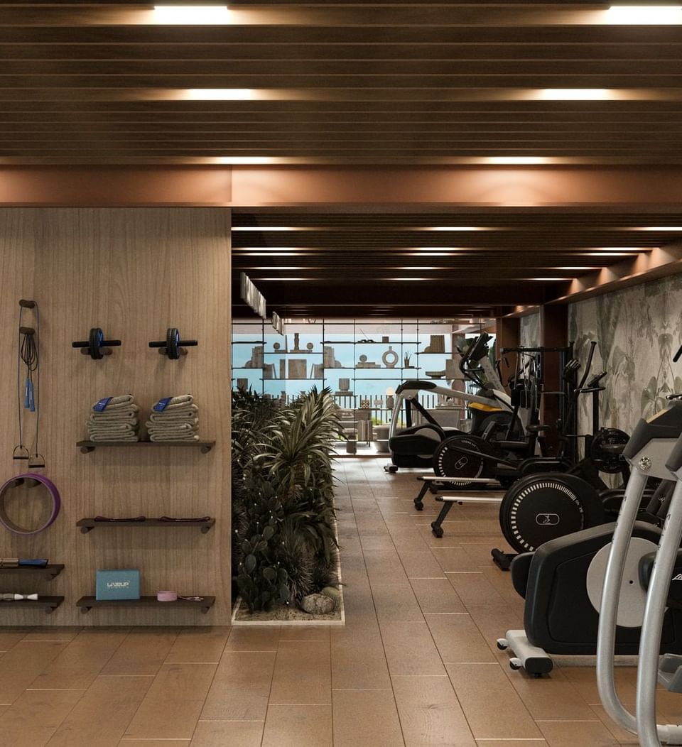 Fitness center at A'ila Resorts, with a variety of modern equipment and a dedicated area for stretching