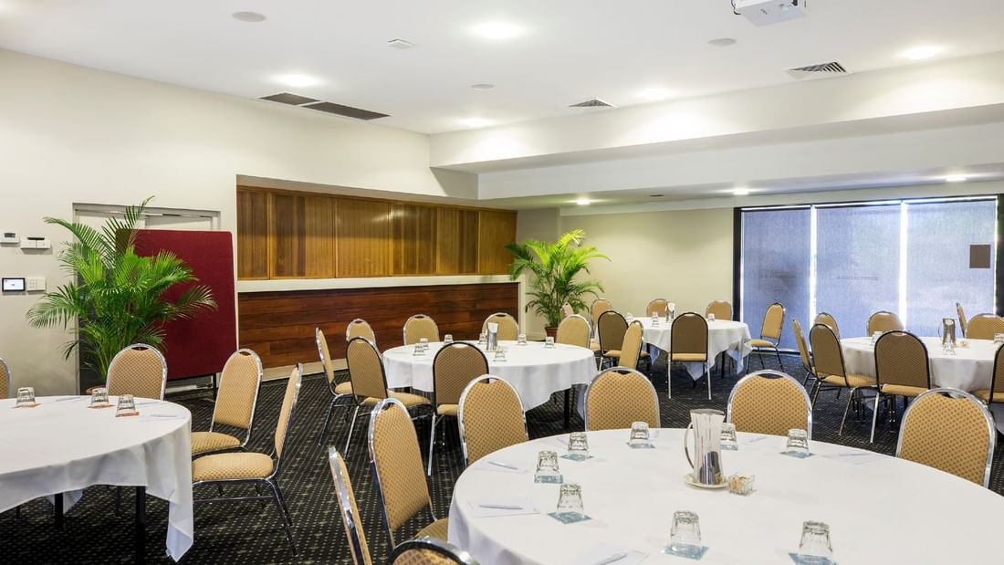 Interior of Burdekin Room with u-shape table set with glassware, and plants at Mercure Hotel Townsville