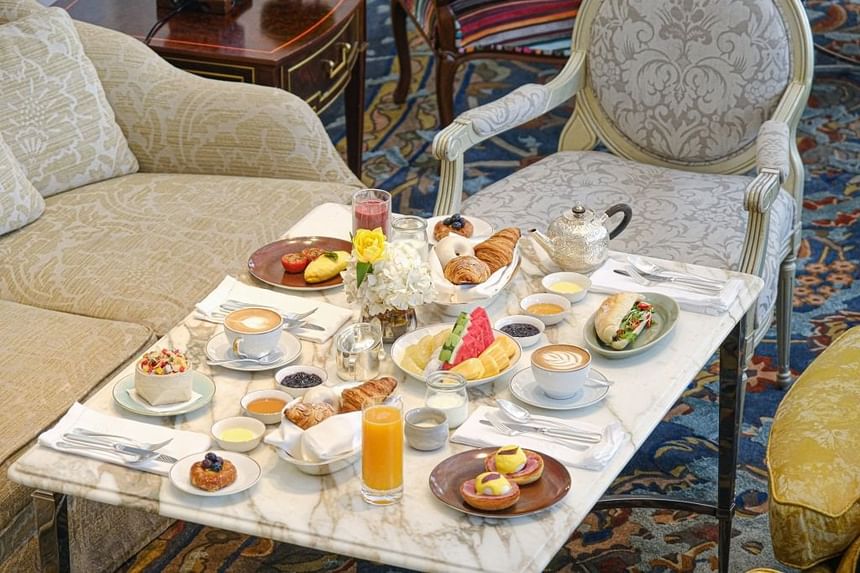 Lavish breakfast of pastries, fruits, drinks, and coffee served on a marble table in Park Lounge at Park Hyatt Saigon
