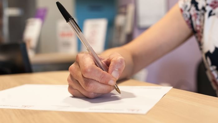 Close up of woman hands writing on a desk at Hotel Continental