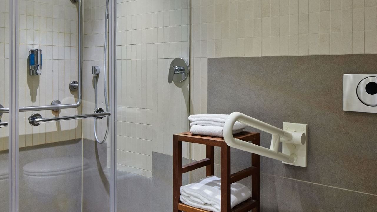 Superior Room bathroom with shower cubicle, towels on a wooden rack at Titanic Comfort Mitte