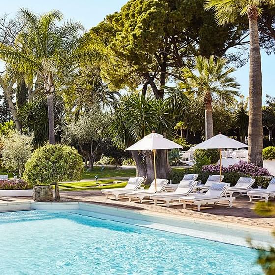 Outdoor pool area with pool lounges at Marbella Club Hotel