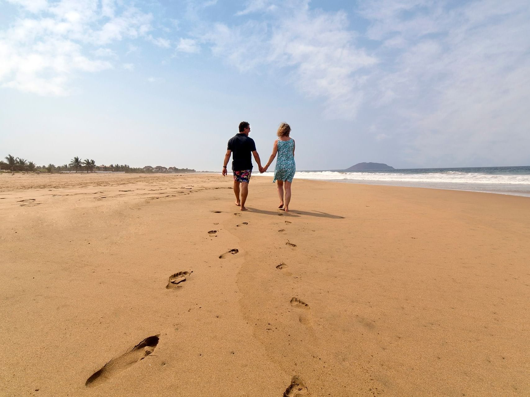 Couple walking on the beach near Marea Beachfront Villas