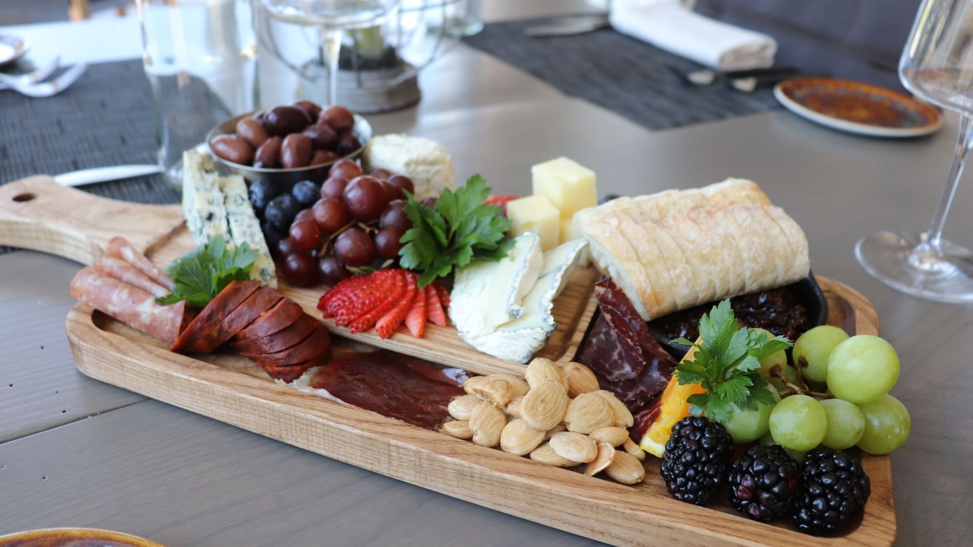 Various fruits and meats arranged on a wooden board served in 1936 at Camp Creek Inn