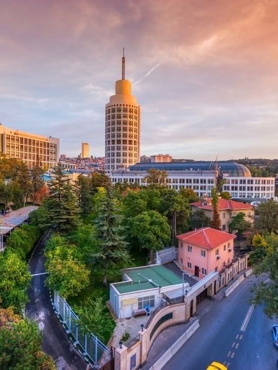 Street view of Museum of Anatolian Civilizations by green trees surrounding a winding road near Warwick Ankara