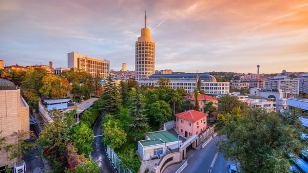 Street view of Museum of Anatolian Civilizations by green trees surrounding a winding road near Warwick Ankara