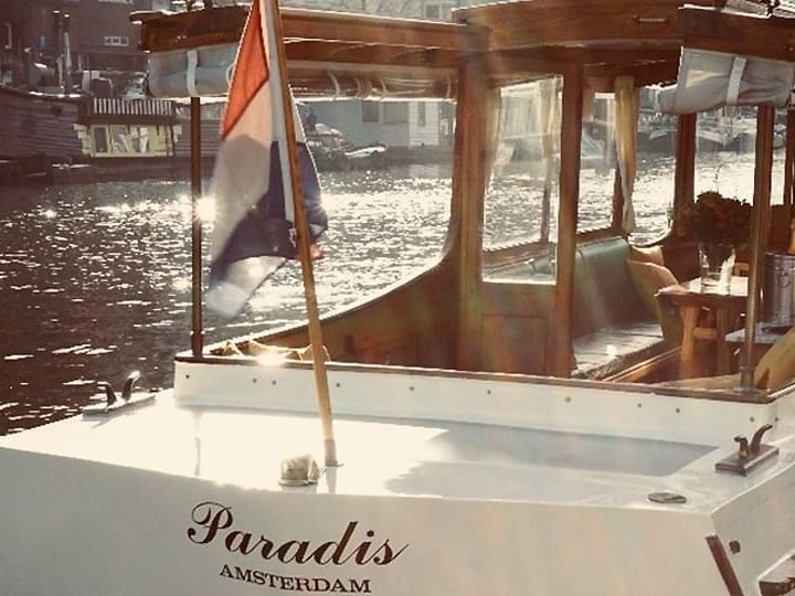 Paradis Amsterdam boat on water near Luxury Suites Amsterdam