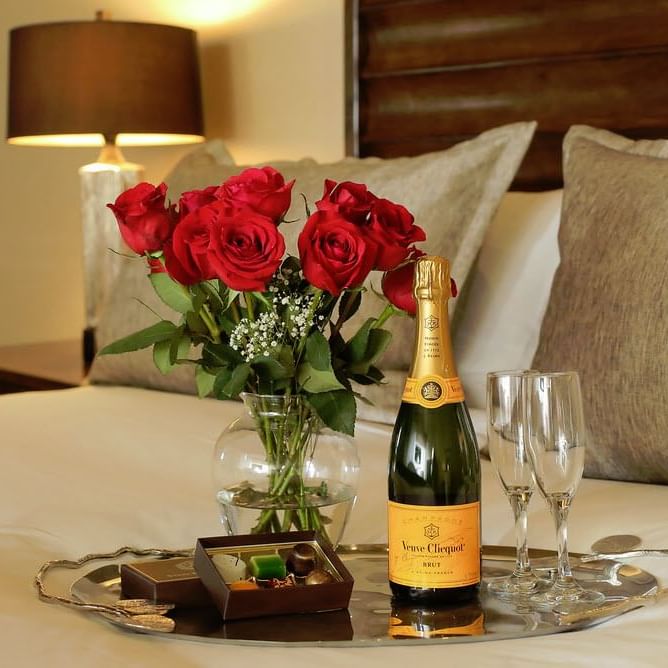 A champagne bottle & glasses on a bed in a room at Stein Lodge