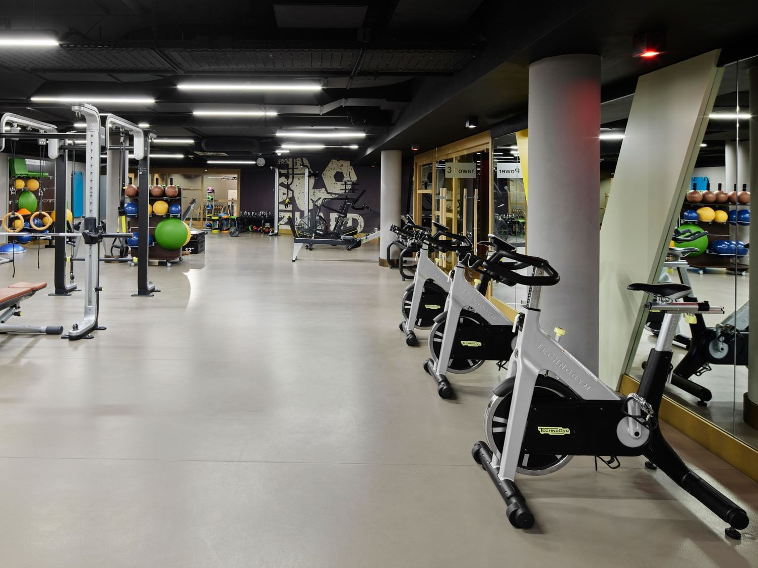 Modernes Fitnessstudio mit Hanteln, Ergometern und heller Beleuchtung – Titanic Chaussee Berlin.