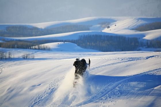 Snowmobile rider on snow near Chateaux Deer Valley