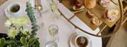 Afternoon tea service featuring a tiered tray by a teacup and a flower vase at Warwick Allerton Chicago