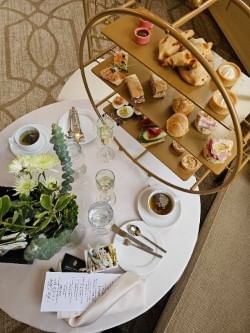 Afternoon tea service featuring a tiered tray by a teacup and a flower vase at Warwick Allerton Chicago