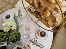 Afternoon tea service featuring a tiered tray by a teacup and a flower vase at Warwick Allerton Chicago