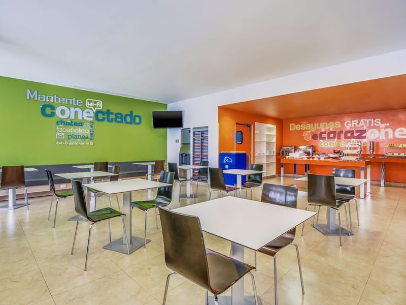 Amplia sala de desayunos con TV y carteles en las paredes en One Hotels