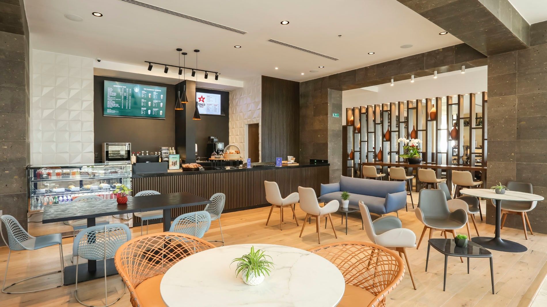 Token Café con barra de mármol, asientos variados y elegante panel de madera en Camino Real Veracruz