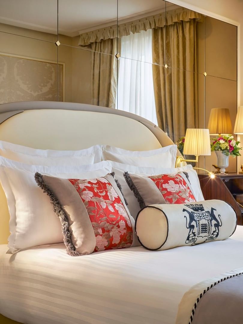 Bed with pillows under a hanging lamp beside a desk in Superior Double Room at Hotel Westminster Paris