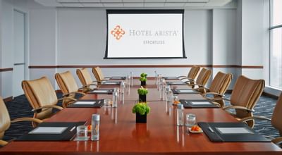 a conference table facing a projector screen