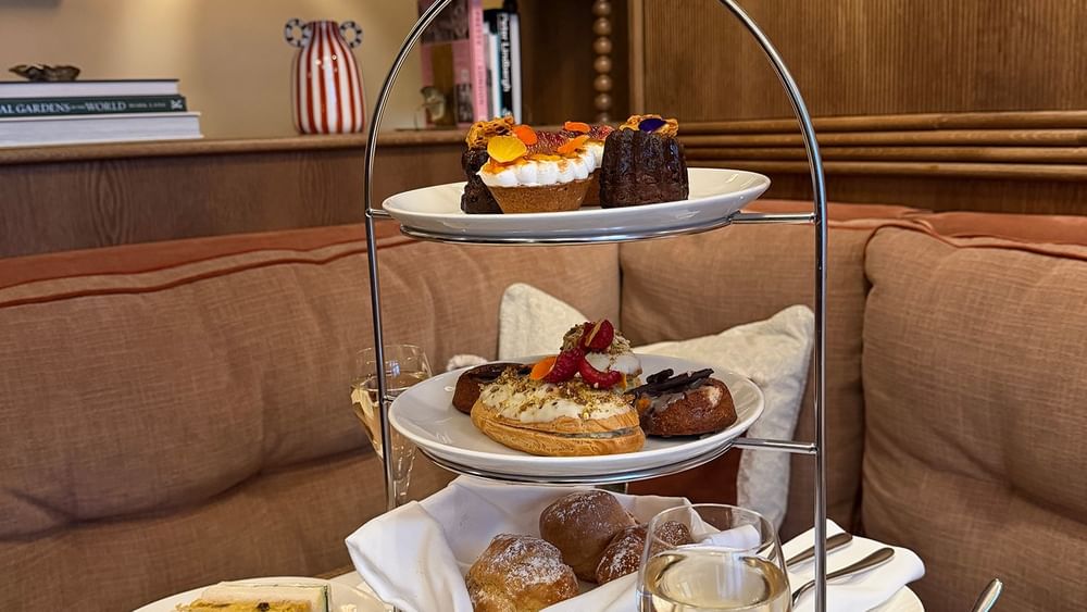 Traditional British Afternoon Tea with assorted desserts and drinks at The Capital Hotel, London.