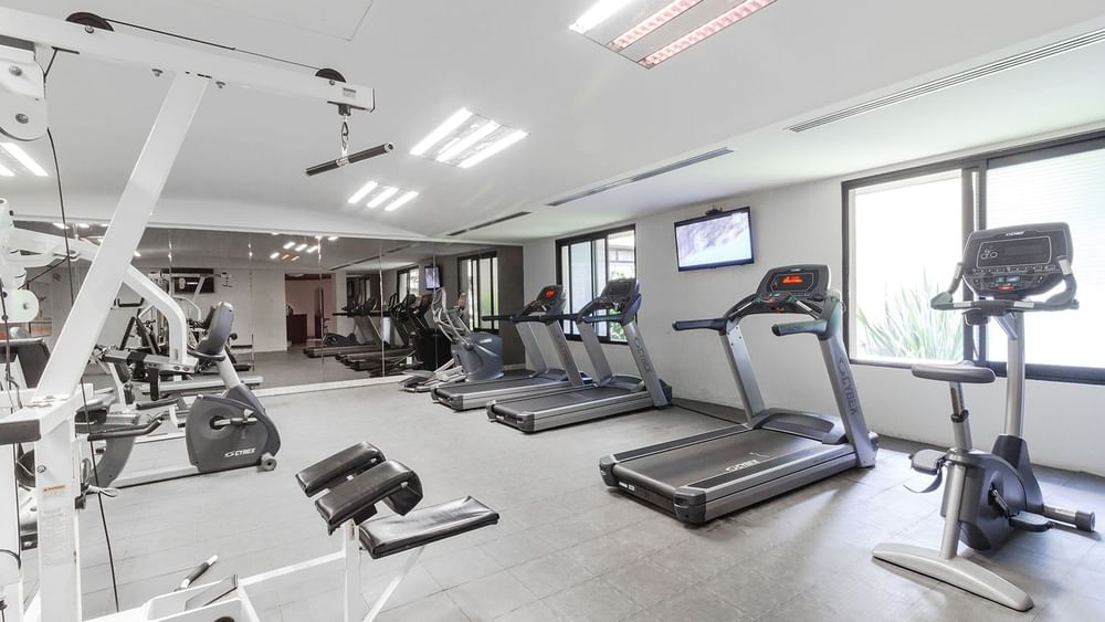 Brightly lit fitness center featuring modern treadmills and cardio machines at Camino Real Guadalajara