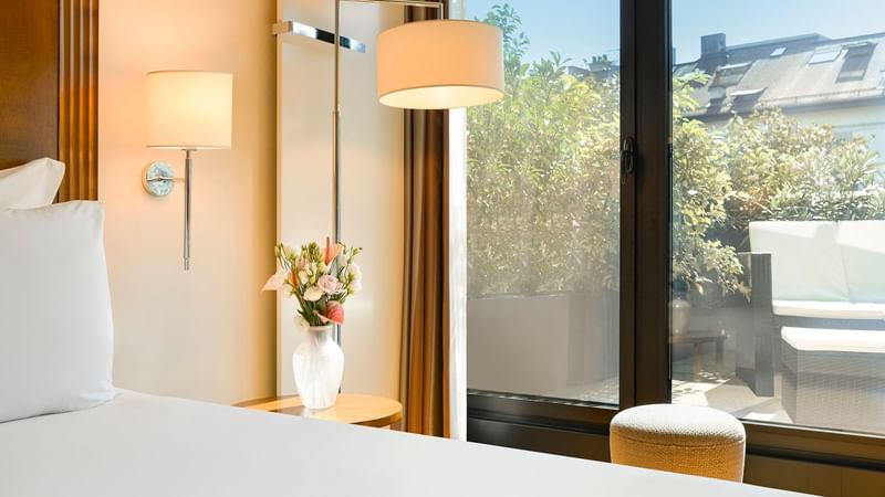 Bed & balcony lounge area in Classic Terrace Room at Warwick Geneva