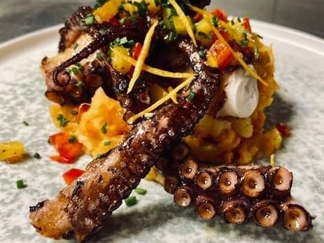 Octopus dish served in a restaurant at The Originals Hotels