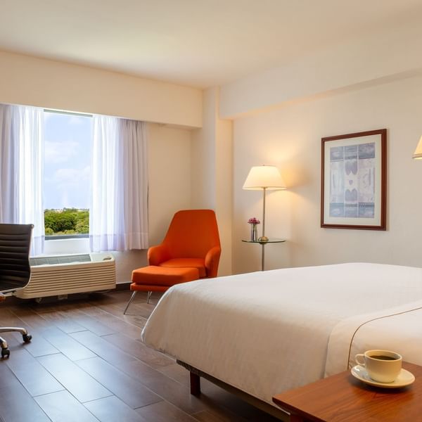 Closeup on king bed & lounge in Superior Room at Fiesta Inn