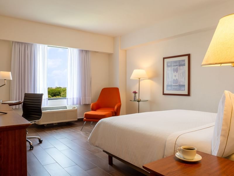 Closeup on king bed & lounge in Superior Room at Fiesta Inn