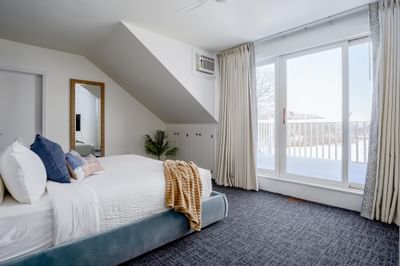 Guest room with a bed and large windows at Ogunquit River Inn