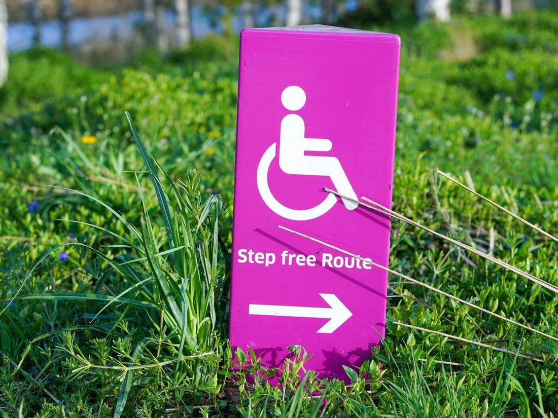 Vibrant magenta sign at The Sebel Mandurah indicating a wheelchair-accessible Step Free Route