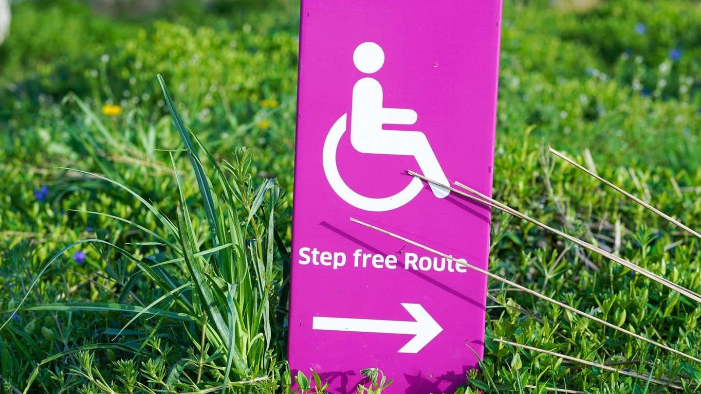 Vibrant magenta sign at The Sebel Mandurah indicating a wheelchair-accessible Step Free Route