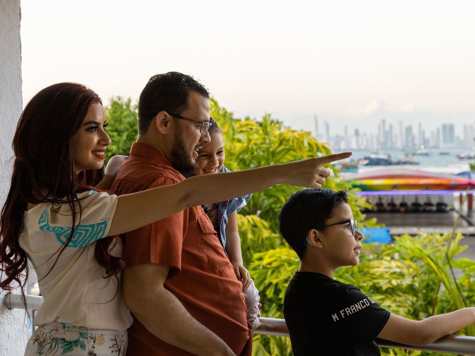 Family looking at a skyline from a balcony at MARINN Tropical Vibes Hotel