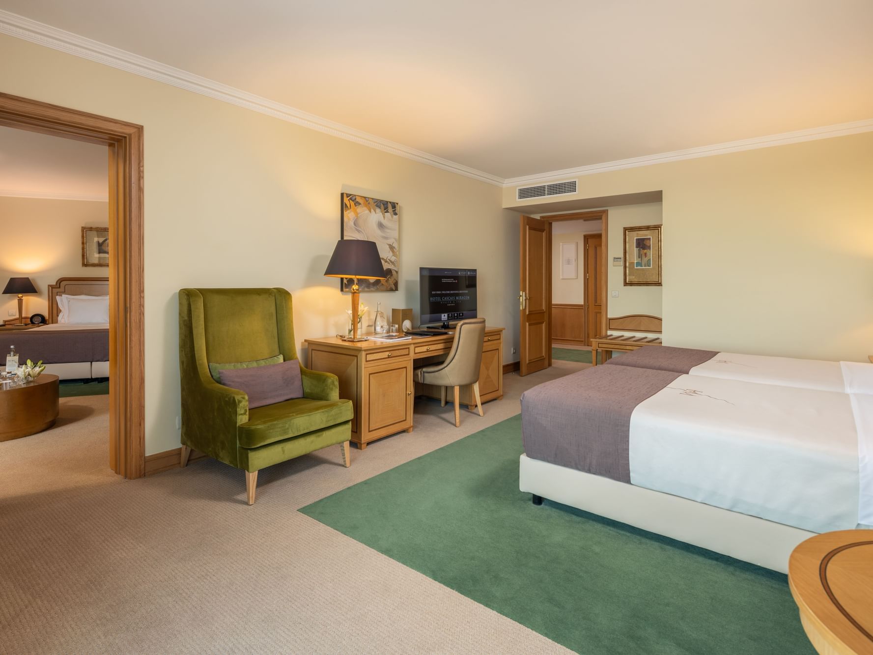 Work desk, TV, and cozy lounger facing the beds in Family Room Sea View at Hotel Cascais Miragem Health & Spa