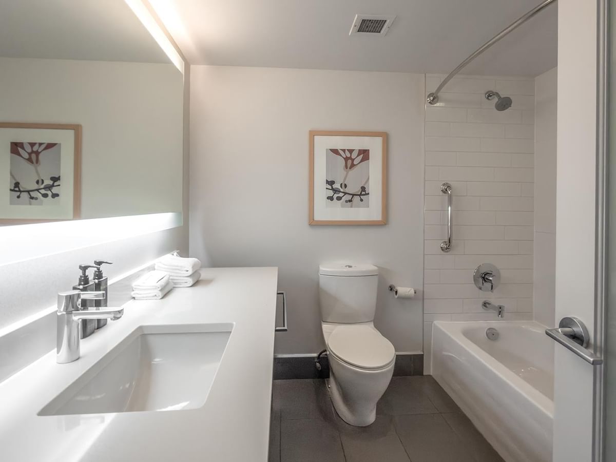 Modern bathroom with a bathtub, toilet, and sink at Coast Bastion Hotel in Nanaimo.
