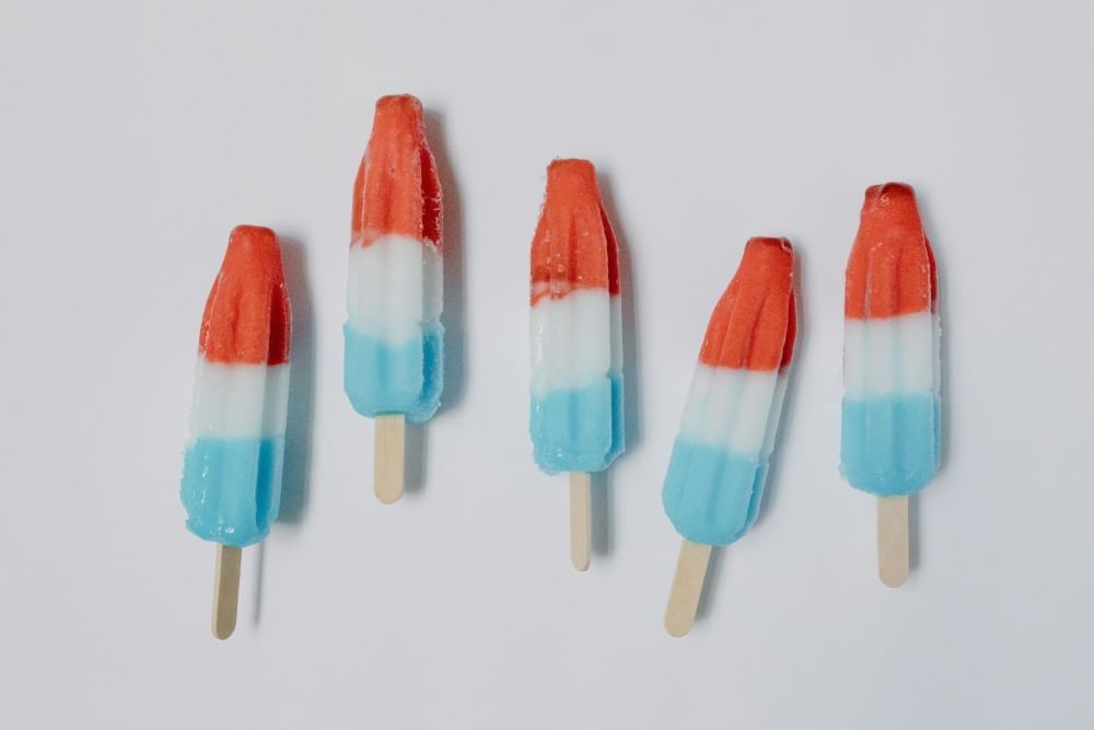 Red, white, and blue popsicles against a gray backdrop.