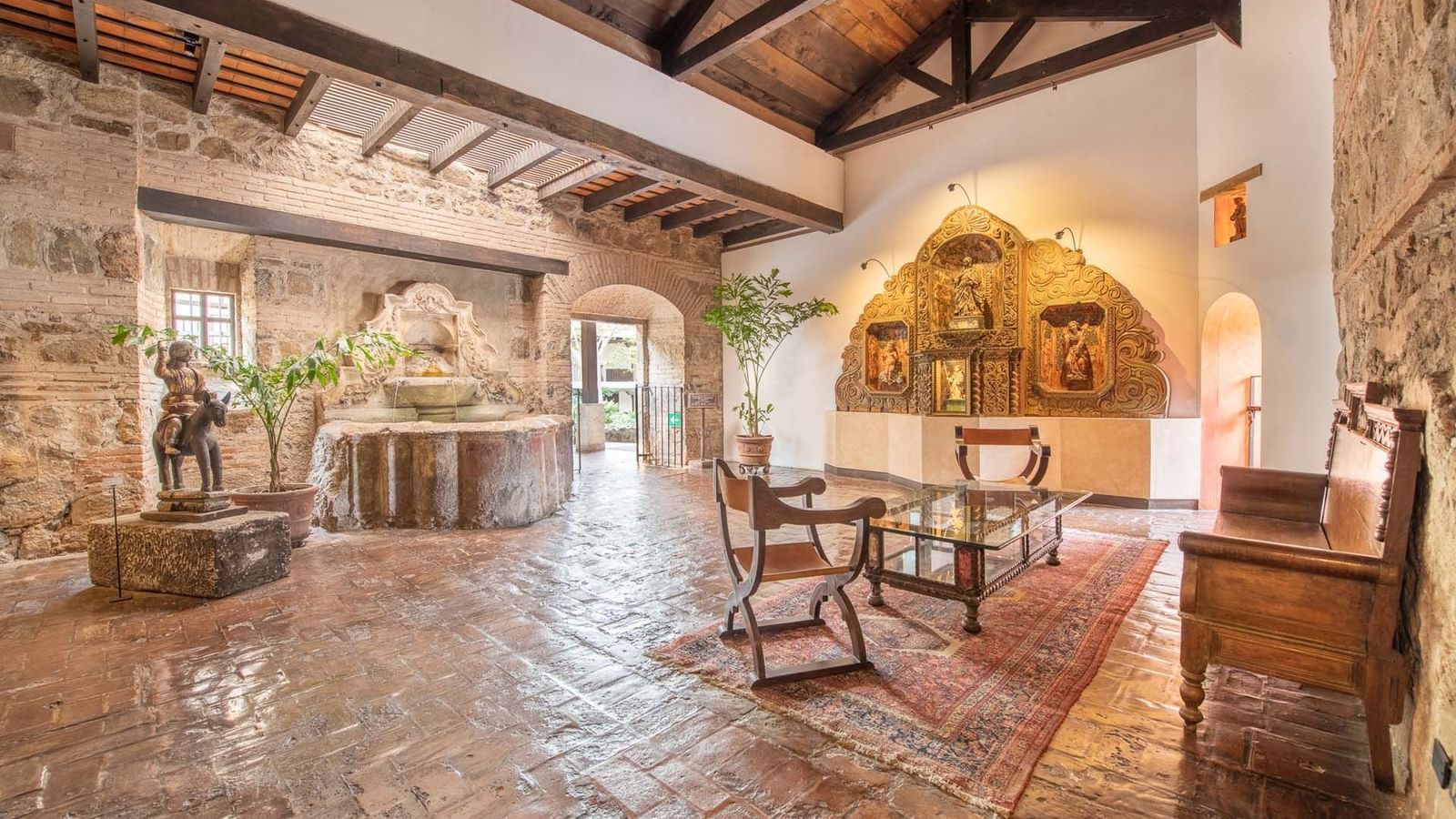 Luminosa y acogedora recepción de hotel en Casa Santo Domingo, con una hermosa fuente y elegante mobiliario antiguo