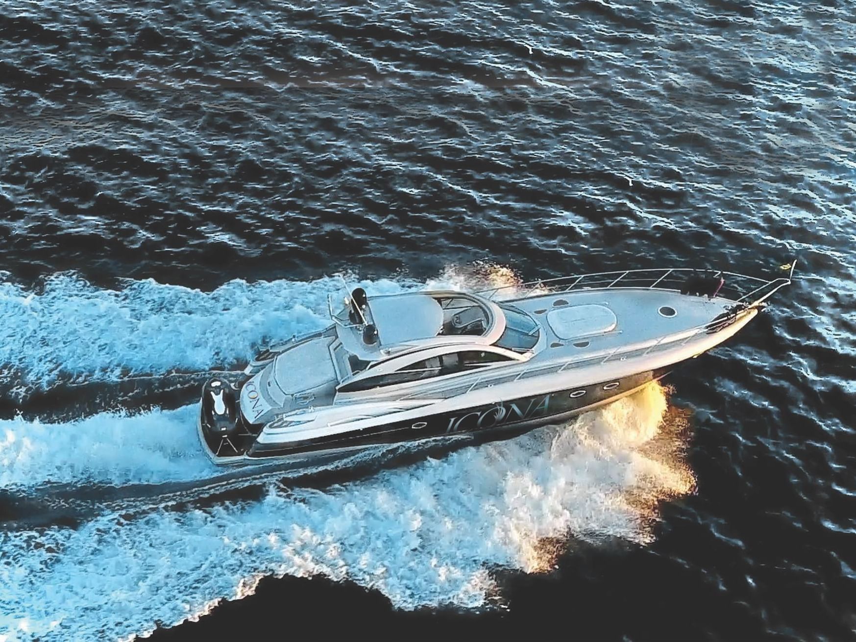 A yacht speeding in the water near ICONA Avalon Resort
