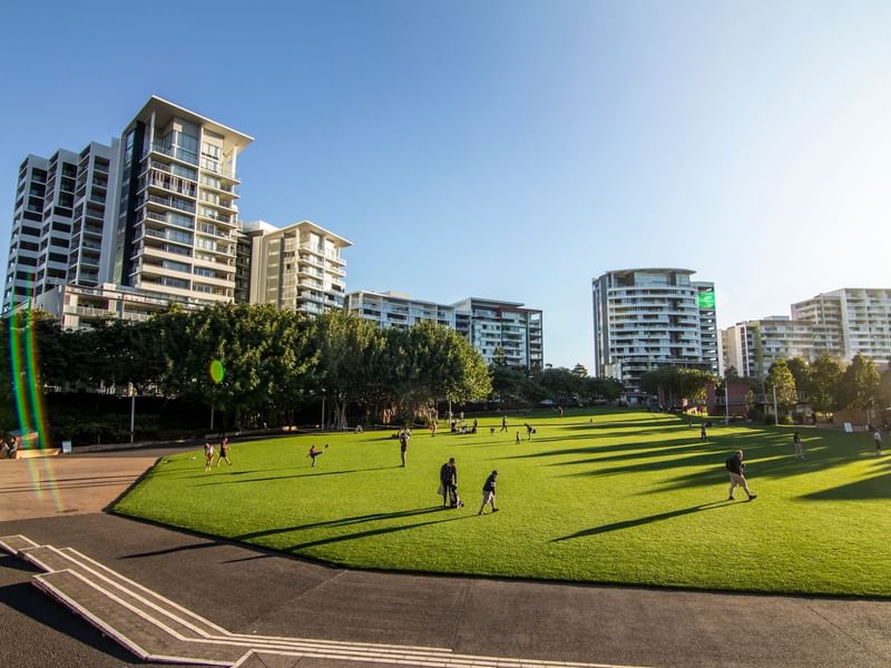 Roma Street Parklands with people and modern buildings on a sunny day near Sofitel Brisbane Central