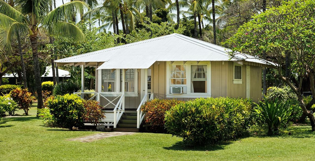 Cottage surrounded by trees and garden